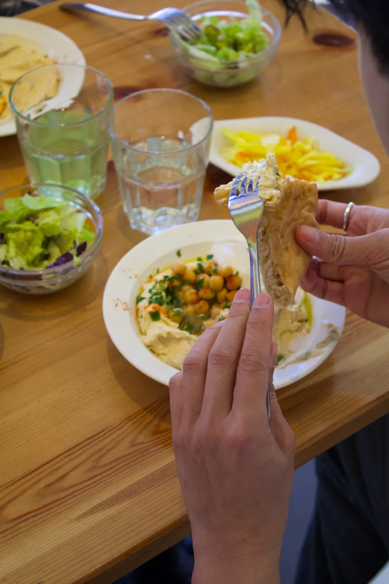 Gäst äter hummus med pitabröd